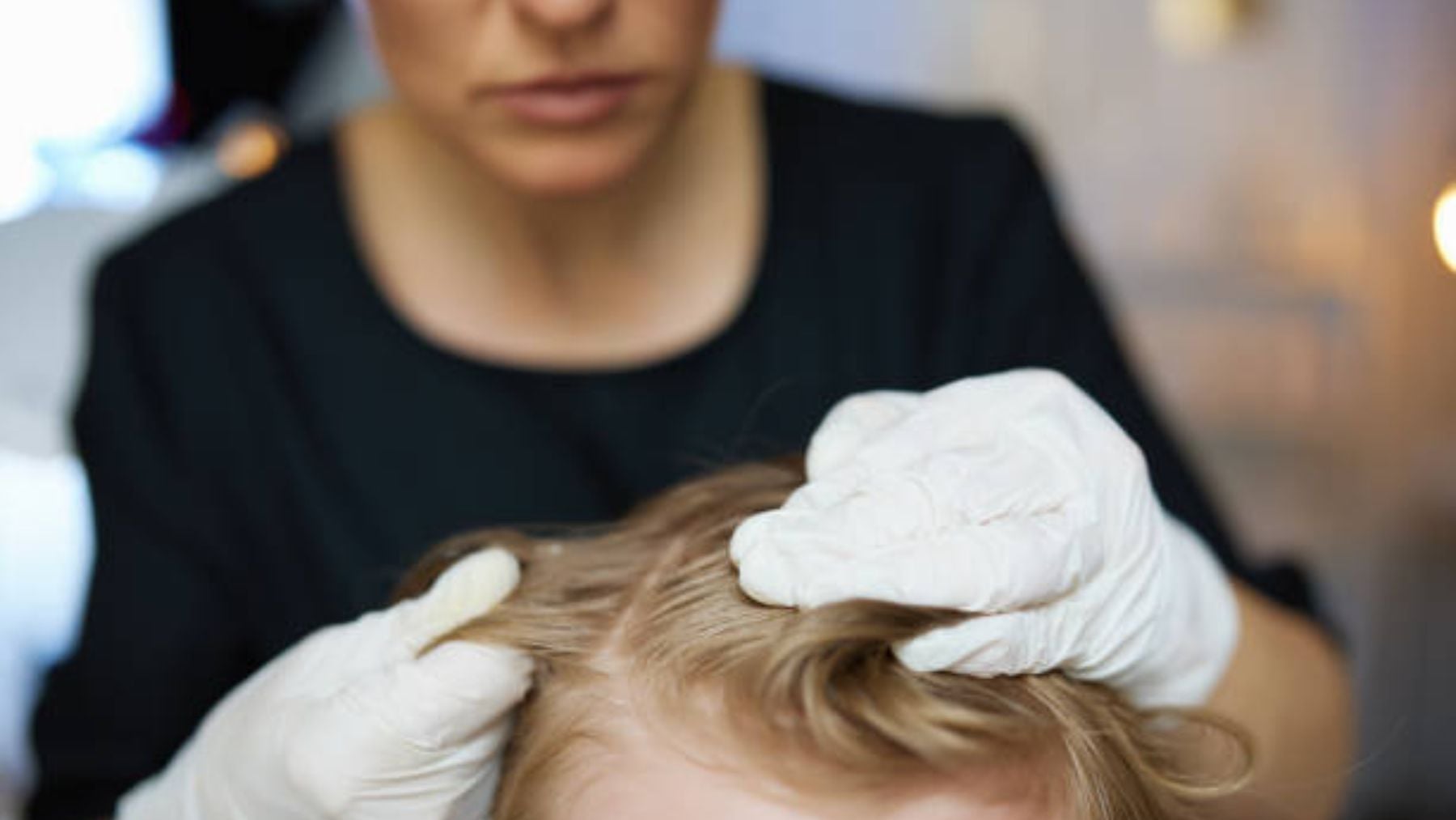 Una madre revisa a su hijo para comprobar que no tiene piojos.