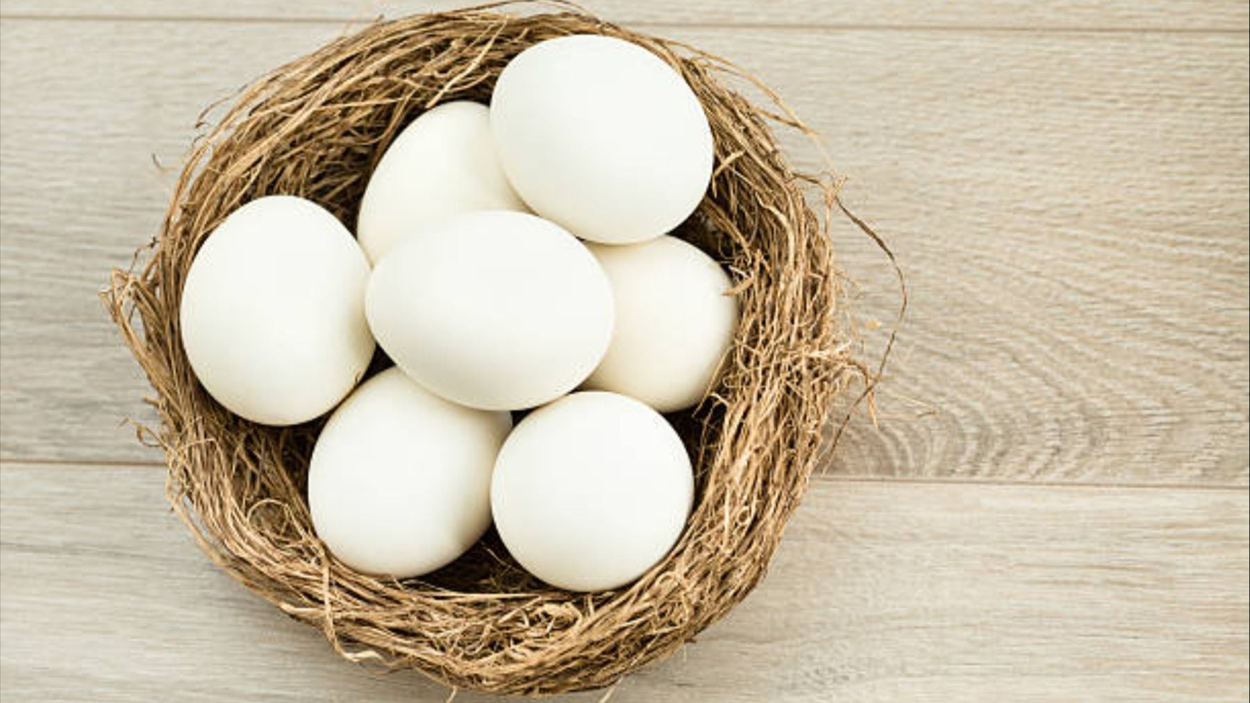 Una cesta con huevos blancos.