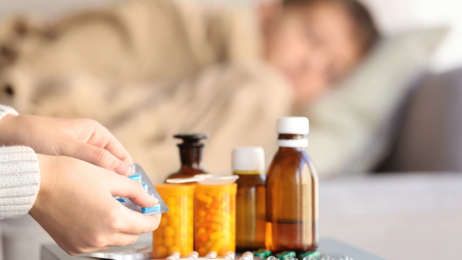 Una madre le da un medicamento a su hijo.