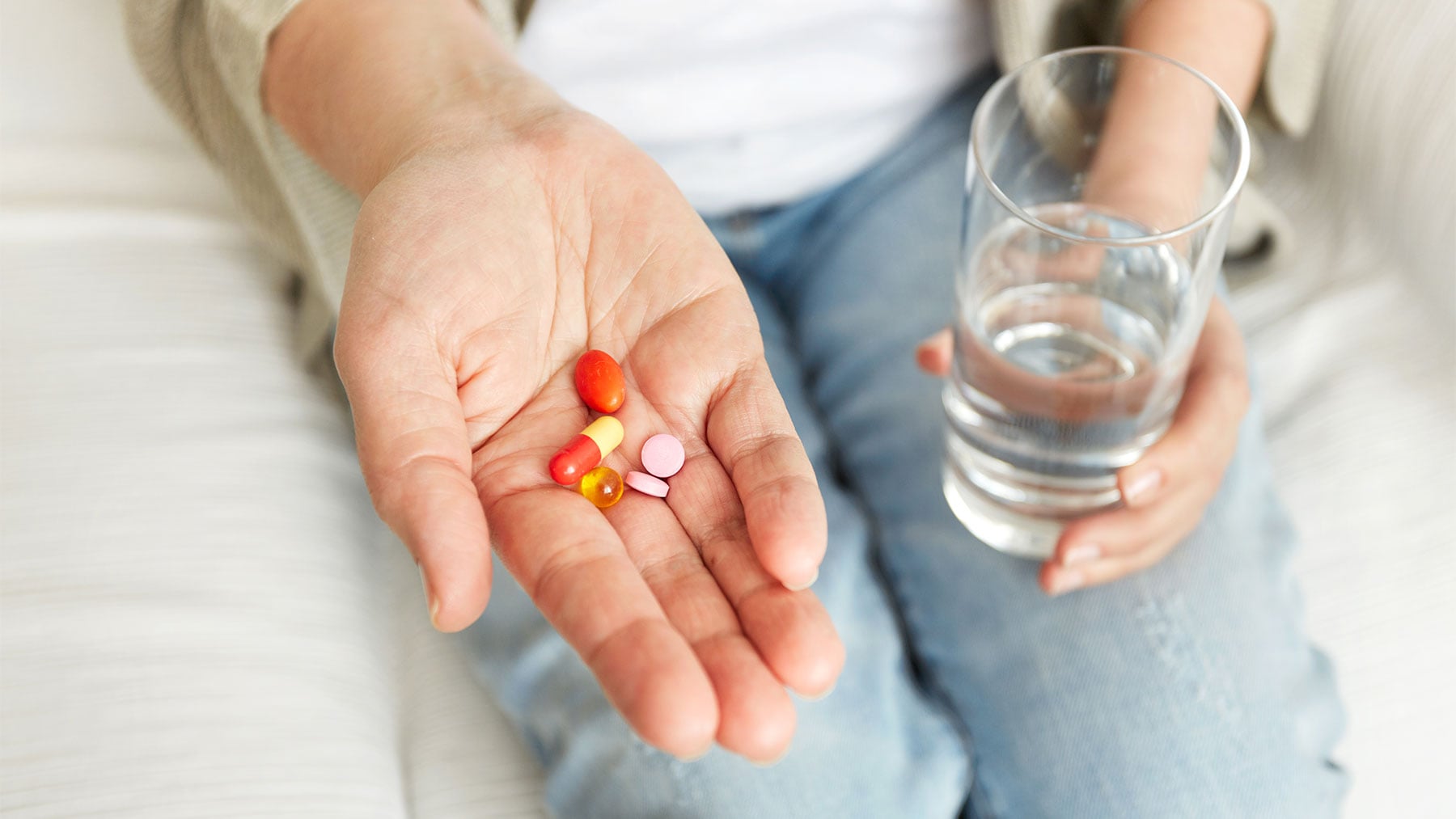 Una mujer sostiene en su mano varias pastillas.